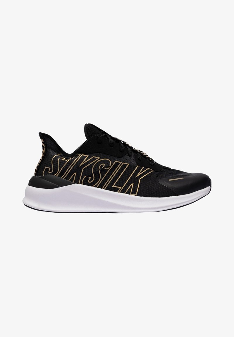 Chaussure de sport noire avec une tige en mesh, arborant le logo "SIKSILK" doré, une semelle intermédiaire blanche amortissante et une semelle extérieure en caoutchouc noire texturée.