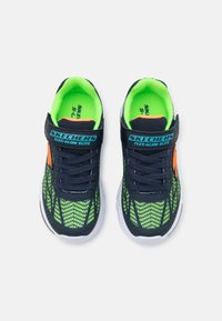 Sneakers Skechers con parte superiore in rete blu navy, accenti verde neon, lacci neri, dettagli arancioni e suola in gomma bianca.