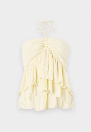 Haut jaune sans bretelles avec un corsage froncé, présentant des volants superposés. Fabriqué en tissu léger avec une texture douce. Se noue à l'arrière du cou.