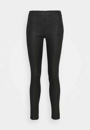 Leggings negros con un patrón texturizado y un diseño ajustado. La cinturilla es elástica, lo que garantiza un ajuste ceñido y flexibilidad.