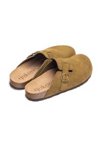 Brown suede slip-on shoes with a buckle strap, cork footbed, and textured soles, featuring a simple, rounded design for comfort.