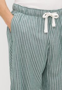 Heledad hallo roheline triibuline lounge-püksid, mis on valmistatud pehmest kangast. Omab elastset vöökohta, millel on pael ja küljetaskud.