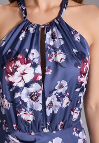 Robe halter en satin bleu marine avec des fleurs roses et blanches. Dotée d'un détail en clé et d'une taille froncée pour une silhouette ajustée.