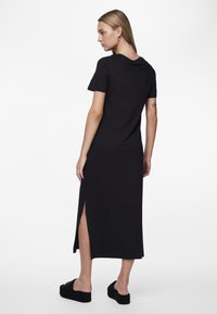 Must mustriga t-särk-kleid, millel on lühikesed varrukad ja külgvoodrid, valminud pehmest kangast, ümmarguse kaela ja sirge lõikega.