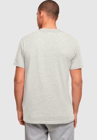 Graues kurzärmeliges T-Shirt mit Rundhalsausschnitt, aus weicher Baumwollmischung, mit lockerer Passform und ohne sichtbare Grafiken oder Muster.