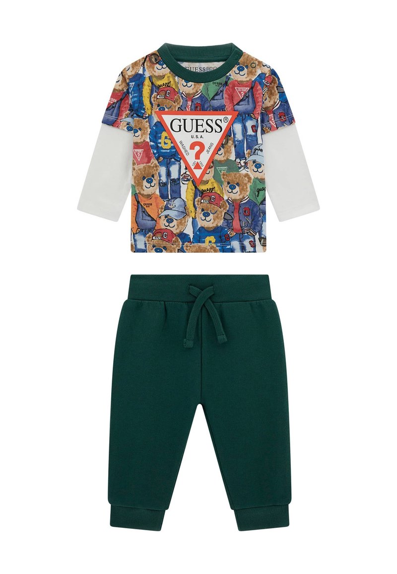 Dviejų dalių apranga, susidedanti iš ilgomis rankovėmis marškinėlių su spalvingu lokio spaudu ir žalių sportinių kelnių su raišteliu.