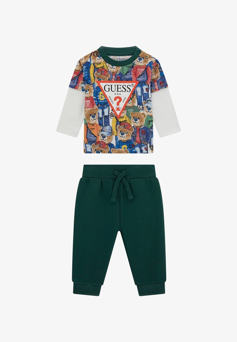 Dviejų dalių apranga, susidedanti iš ilgomis rankovėmis marškinėlių su spalvingu lokio spaudu ir žalių sportinių kelnių su raišteliu.