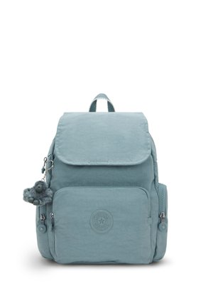 Light blue backpack made from textured material with a flap closure, front zip pocket, circular logo, and a monkey keychain accessory.