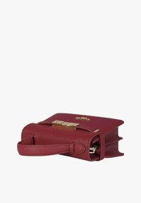 Borsa a mano in pelle rossa con design strutturato, dettagli in metallo dorato e tracolla rimovibile. Texture liscia, stile minimalista.