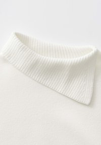 Maglione bianco con colletto a coste. Il tessuto sembra morbido e texture, con un corpo liscio. Il colletto è prominente e ripiegato.