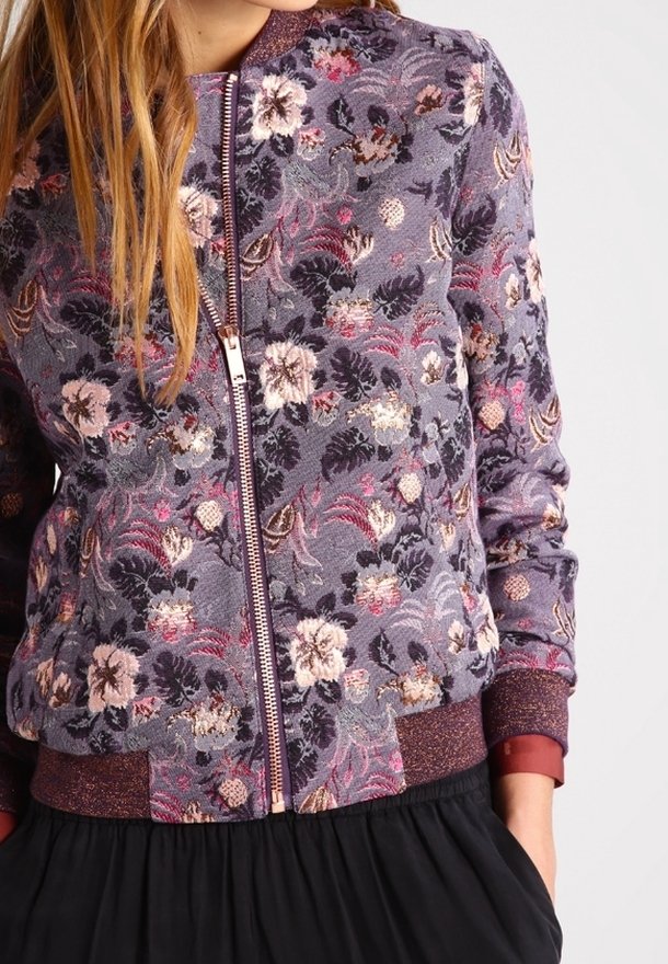 Kwiatowa bomberka w kolorze fioletowym z misternymi haftami w różowym i kremowym kolorze. Posiada zamek błyskawiczny oraz ściągacze przy mankietach i u dołu.
