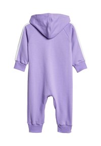 Lila kapucnis overál, puha anyagból készült, fehér oldalcsíkokkal és rugalmas mandzsettákkal a csuklón és a bokán a szoros illeszkedésért.