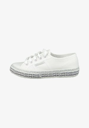 White canvas sneaker with round toe, lace-up front, and a patterned sole featuring repeating "SUPERGA" in black and purple. Flat design.