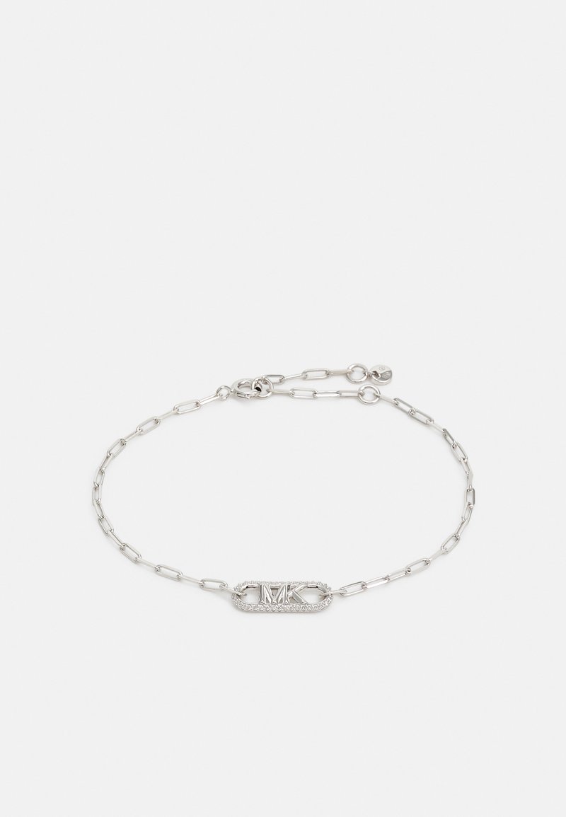 Braccialetto in argento con catena che presenta un ovale centrale collegato con il logo "MK" in rilievo, circondato da piccole pietre trasparenti, superficie liscia e chiusura regolabile.