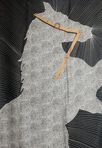 Opera d'arte in bianco e nero che presenta motivi circolari concentrici e linee radiali, con un righello di legno sovrapposto al design.