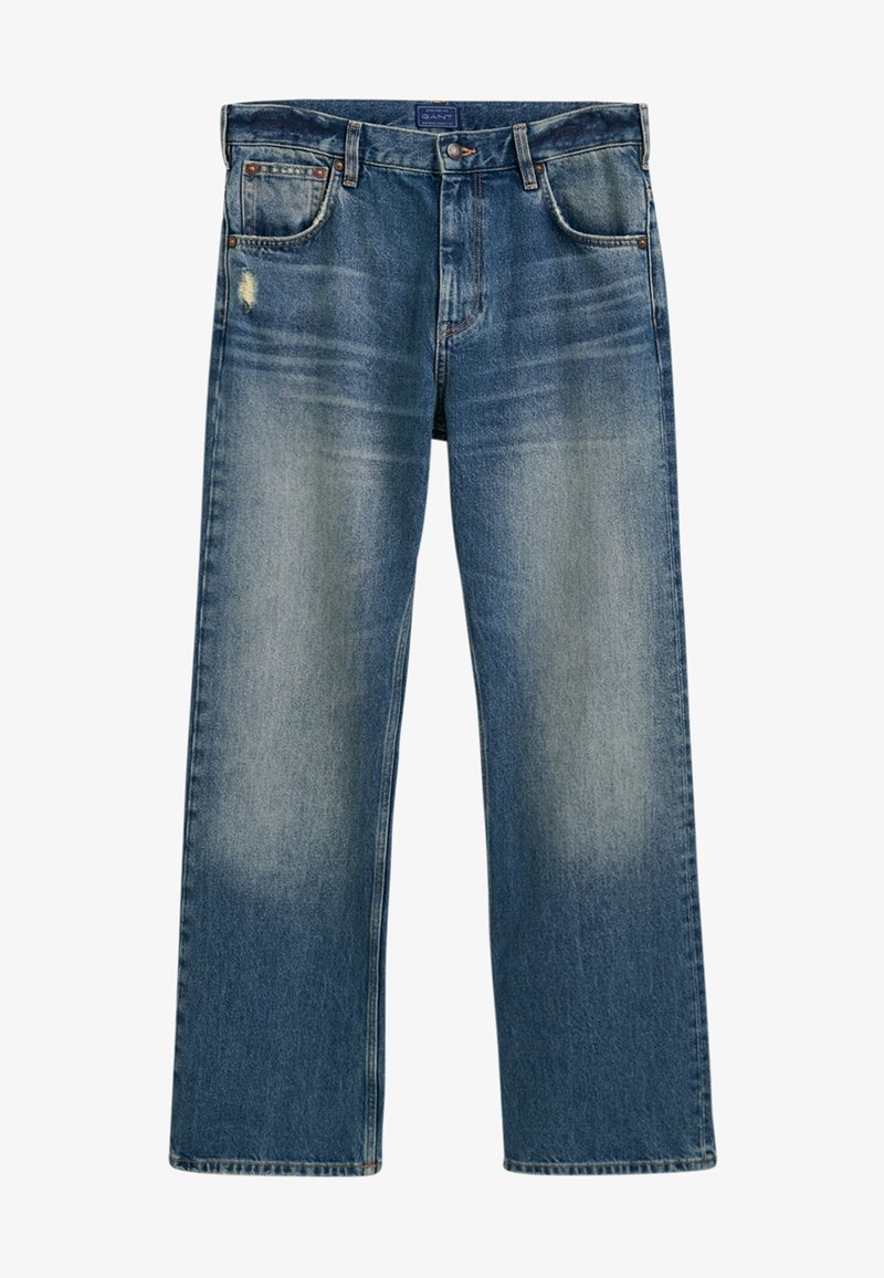 Modré džíny z denimu s uvolněným střihem, s opotřebením na přední straně a lehkým vyblednutím. Mají pět kapes a tradiční knoflíkový uzávěr.