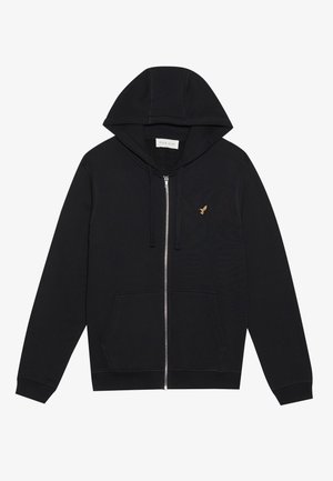 Černá mikina na zip vyrobená z měkké látky, s přední kapsou, nastavitelnou kapucí se šňůrkou a malým zlatým emblémem na levé hrudi.