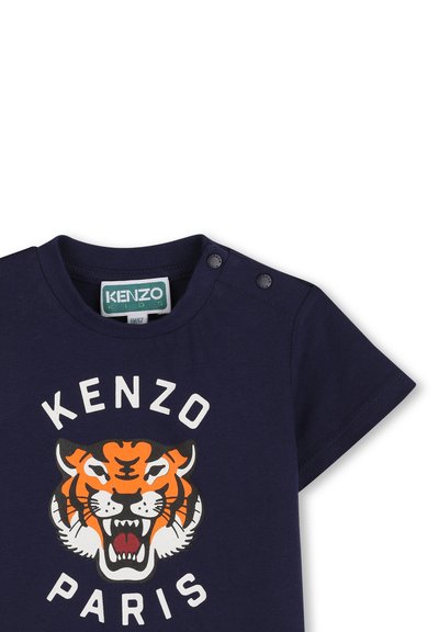 Granatowy bawełniany t-shirt z dużą grafiką tygrysa w kolorze pomarańczowym i czarnym oraz napisem "KENZO PARIS" poniżej; posiada dwa zatrzaski na ramieniu.