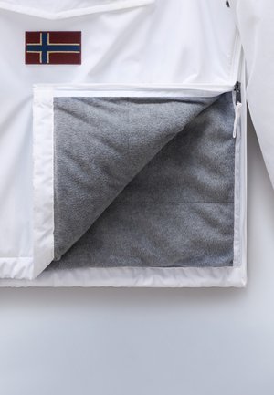 Giacca bianca con patch della bandiera norvegese; la tasca con zip rivela un morbido fodera in pile grigio. Materiale esterno liscio e design pulito.