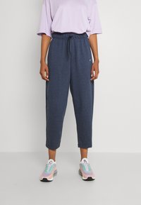 Mörkblå korta sweatpants med elastisk midja och dragsko. Kommer med en ljuslila oversized t-shirt och färgglada sneakers.