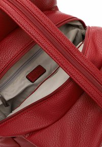 Rote lederne Handtasche mit strukturiertem Finish. Verfügt über einen Reißverschluss und eine hellbeige Innenauskleidung mit einer kleinen Innentasche.