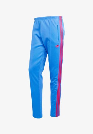 Blue athletic pants with red side stripes, zippered side pocket, elastic waistband, and a small red logo on the thigh.