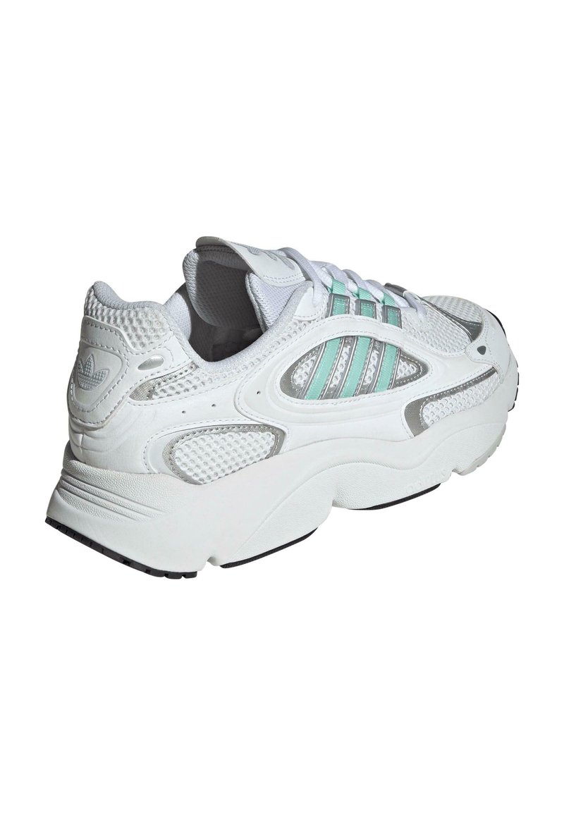 Witte sportieve schoen met mesh panelen, lichtblauwe accentstroken en een gestructureerde zool. Ronde vormgeving met een gevoerde kraag en tong.