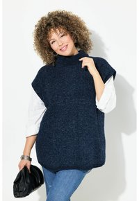 Gilet lavorato a maglia blu navy con colletto alto, maniche corte e finitura strutturata, abbinato a una camicia bianca a maniche lunghe e a una borsa nera.
