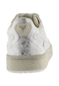 Sneakers argentati con tomaia metallica texture; suola in gomma beige con piccole protuberanze; dettaglio con logo sul tallone.