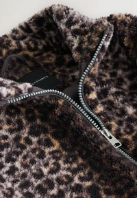 Leoprint-Fleecejacke mit hohem Kragen, ausgestattet mit einem kontrastierenden Reißverschluss in Silber, schwarzem Futter und weichem, strukturiertem Material.