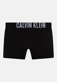 Zwarte katoenen boxershorts met een grijze elastische tailleband waarop het logo "CALVIN KLEIN" staat. Gladde textuur, aansluitend ontwerp, open voorkant.