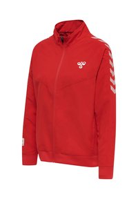 Veste de sport rouge zippée intégralement avec des bandes blanches en forme de chevrons sur les manches et un petit logo blanc d'abeille sur la poitrine, col montant et poignets côtelés.