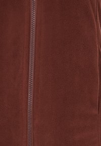 Giacca in pile marrone con superficie texture, dotata di una cerniera centrale di colore coordinato, finitura liscia e senza ulteriori motivi o accenti.