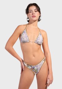 Bikini set s uzorkom leoparda i zlatnim detaljima; trokutasti top i gaćice niskog struka; tkanina djeluje glatko s živopisnim cvjetnim detaljima.