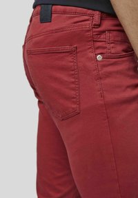 Rote Baumwollhose mit glatter Textur, Gesäßtaschen mit schrägen Klappen und einem genähten Taillenschild.