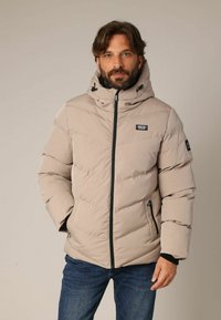 Beige donsjack met een hoge kraag en verstelbare capuchon. Voorzien van een ritssluiting aan de voorkant en zijzakken, een gestructureerde stof en een logopatch.