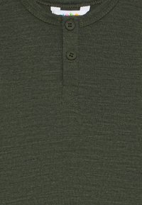 Dunkelgrünes Strick-Henley-Shirt mit zwei Knöpfen an der Knopfleiste und sichtbaren mehrfarbigen Nähten im Kragen.