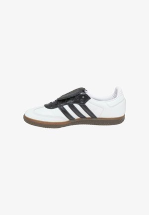 Białe buty sportowe z czarnymi akcentami oraz trzema czarnymi paskami. Posiadają teksturowaną czarną nakładkę na języku. Podeszwa z gumy z wyraźnym bieżnikiem.