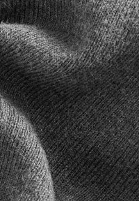 Tessuto lavorato a maglia grigio con una texture morbida, caratterizzato da un motivo a coste. La superficie presenta leggere variazioni di tonalità, enfatizzando la profondità.