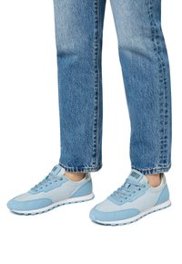 Ljusblå sneakers med design i blandade material, med släta och texturerade ytor, snören och vita sulor.