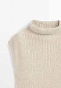 Pull à col roulé beige côtelé avec un col haut et une coupe ajustée, doté d'une texture douce, idéal pour le superposer.