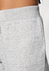 Fascia in cotone grigio con una texture morbida, caratterizzata da un design a coste e un leggero motivo mélange. Nessun hardware visibile.
