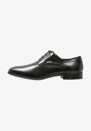 Schwarzer Herrenschuh aus Leder mit Schnürsenkeln, spitzer Schuhspitze, niedrigem Absatz und seitlicher Steppnaht.