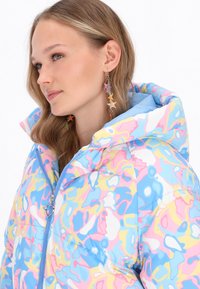 Damenjacke mit einem gepolsterten Design in einem blauen, pinken und gelben abstrakten Muster. Mit hohem Kragen, Reißverschluss und betonten Nähten.