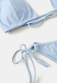 Hellblaues Bikini-Set mit Dreiecksschalen und verstellbaren Schnürungen auf weißem Hintergrund.