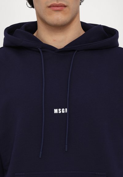 Navy blue hoodie made of soft fabric featuring a white "MSGM" logo on the chest and drawstring accents on the hood.