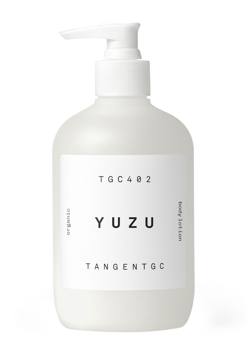 Bottiglia opaca bianca con pompa, etichettata "YUZU", contiene lozione per il corpo biologica. Design semplice con testo nero e una texture liscia.