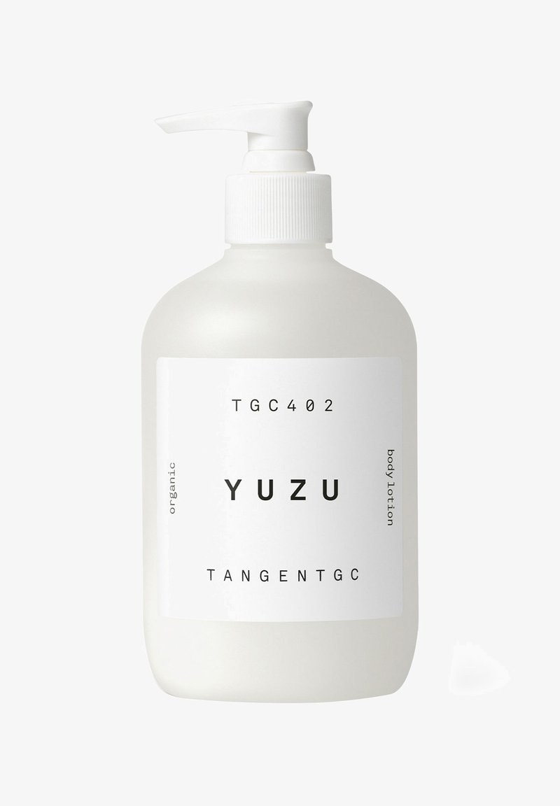White opaque bottle with a pump, labeled "YUZU", contains organic body lotion. Simple design with black text and a smooth texture.
