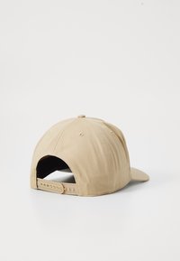 Beige baseballcaps med en strukturert form, sømdetaljer og justerbar snapback-lukking; laget av bomull; glatt tekstur.