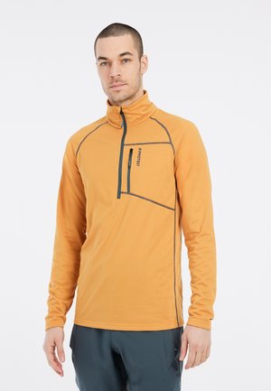 Pitkähiha, vetoketjullinen fleece-pullover, jossa on oranssi väri, tummansiniset kontrastitikkaukset ja rintatasku; pehmeä rakenne, joka soveltuu kerrospukeutumiseen.